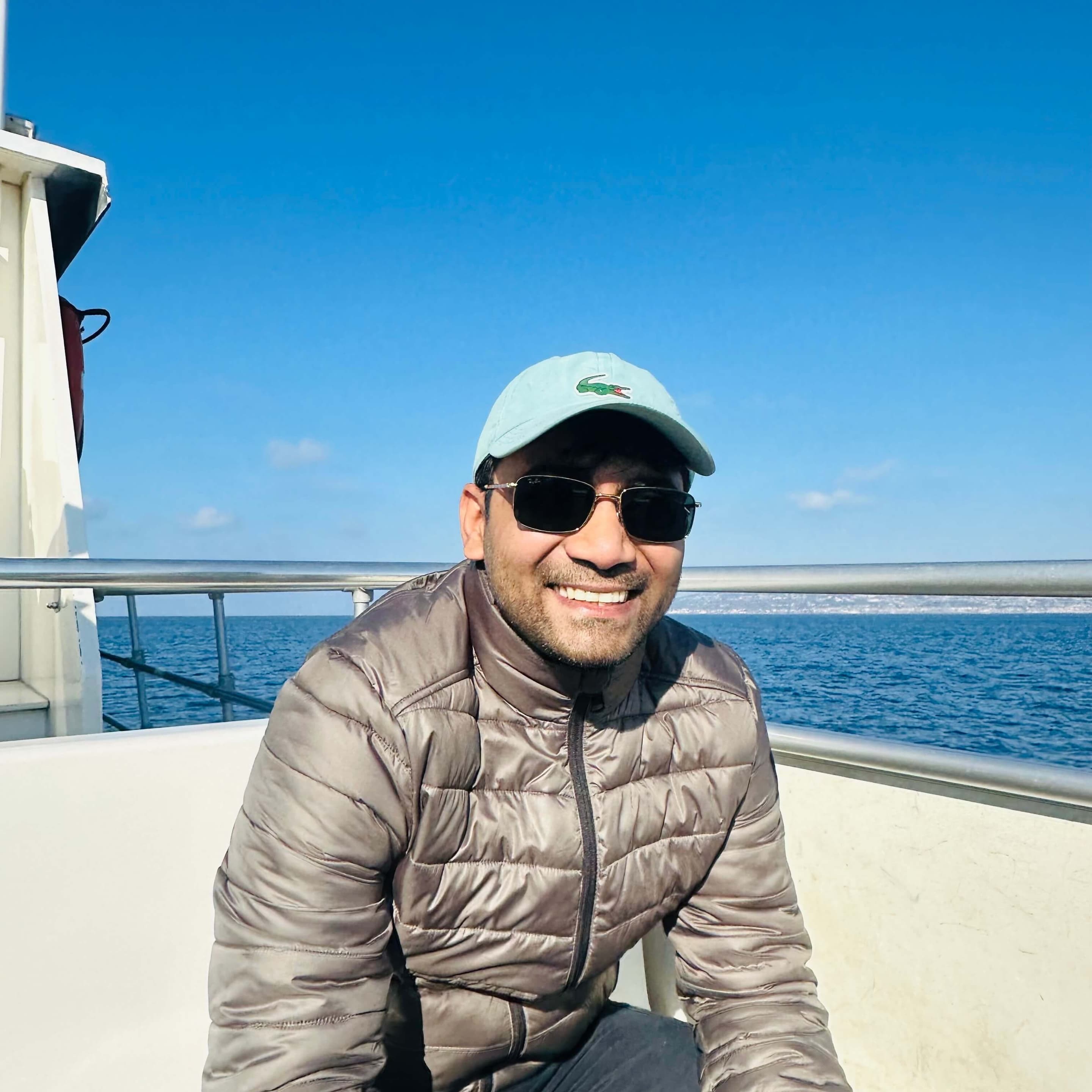 Rippler Hitendra Katiyar on a boat, with a view of the horizon and a clear blue sky.